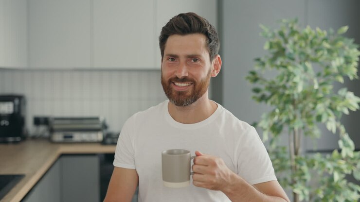 uomo che beve caffè in cucina