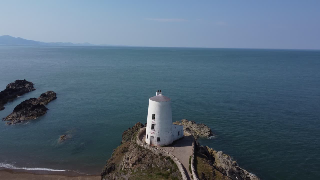 vista aérea en órbita de la ruta de senderismo costera de ynys llanddwyn y el faro de piedra de goleudy tŵr mawr, anglesey