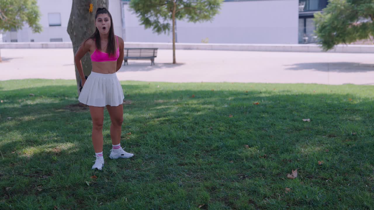 Giovane donna che gioca a tennis nel parco