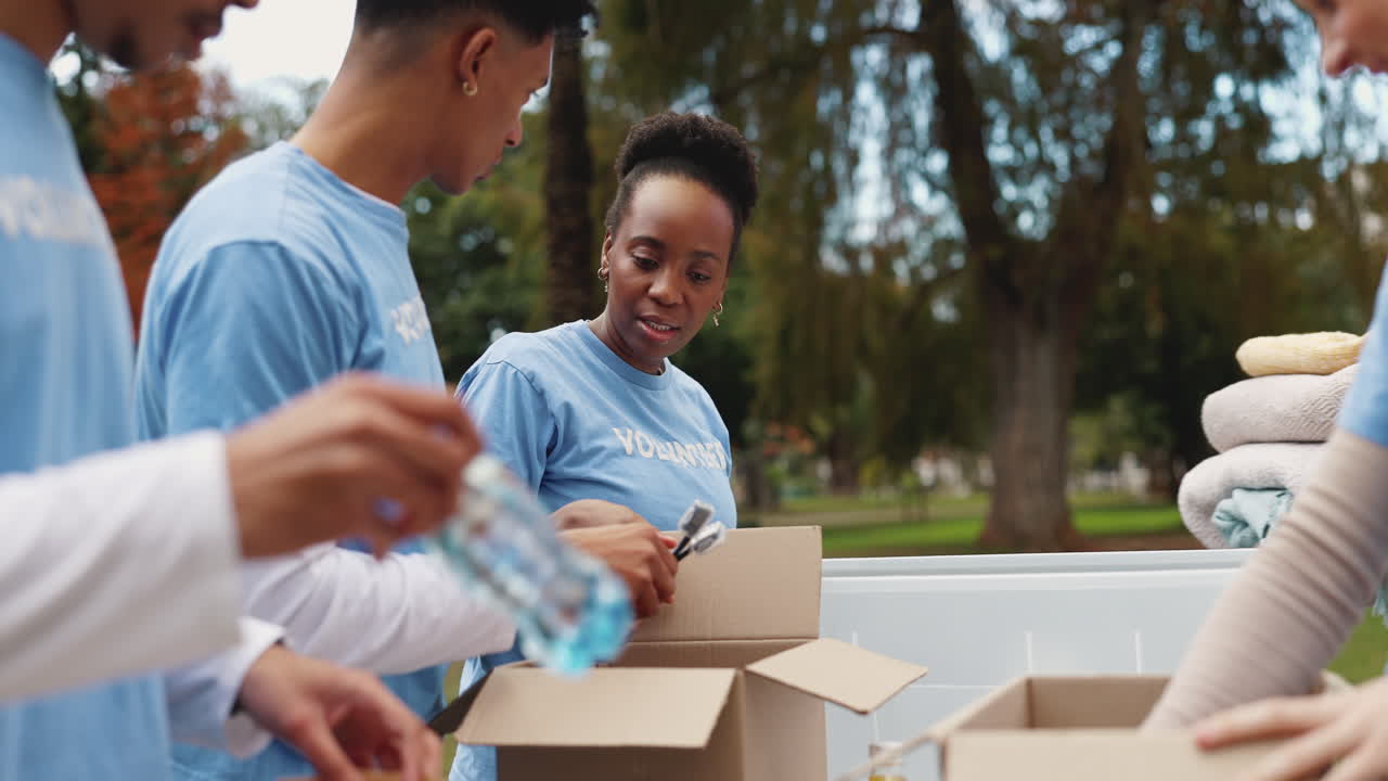 Group of young people volunteering and donating clothes at a park