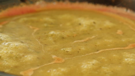 cooking traditional indian meal palak panir with spinach and cheese close up. palak paneer is an indian dish, consisting of paneer in a thick paste made from pureed spinach, palak paneer is prepared by first boiling and pureeing spinach.