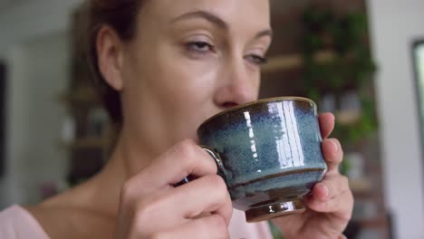 Woman-drinking-coffee-in-kitchen-at-comfortable-home-4k