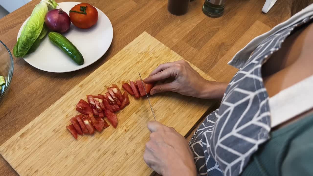 женщина режет помидоры на салат.