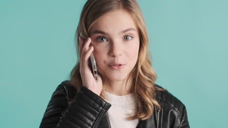 Teenage-Caucasian-girl-in-leather-jacket-talking-on-the-phone.