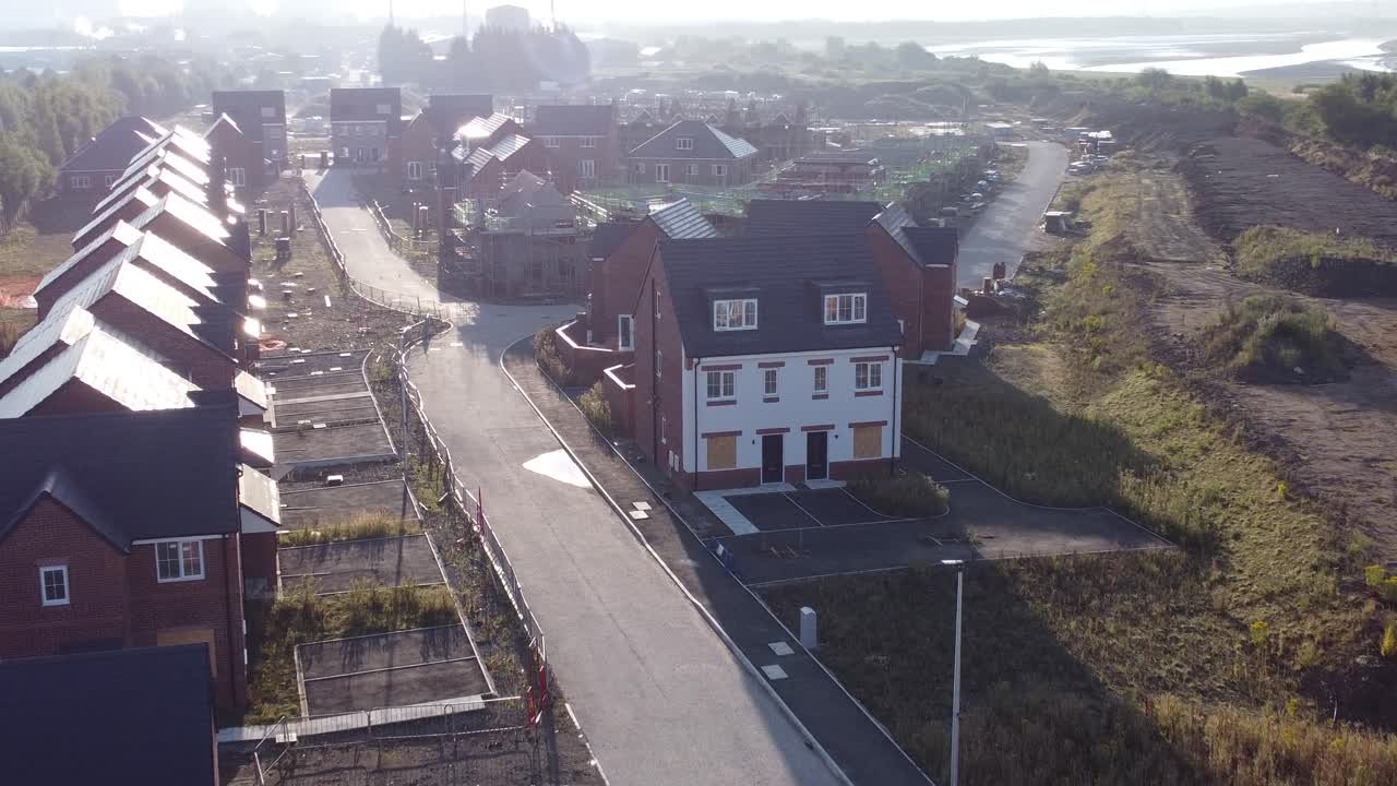 Luftfoto af morgensolopgang over britisk forstadshusudviklingsbyggeplads