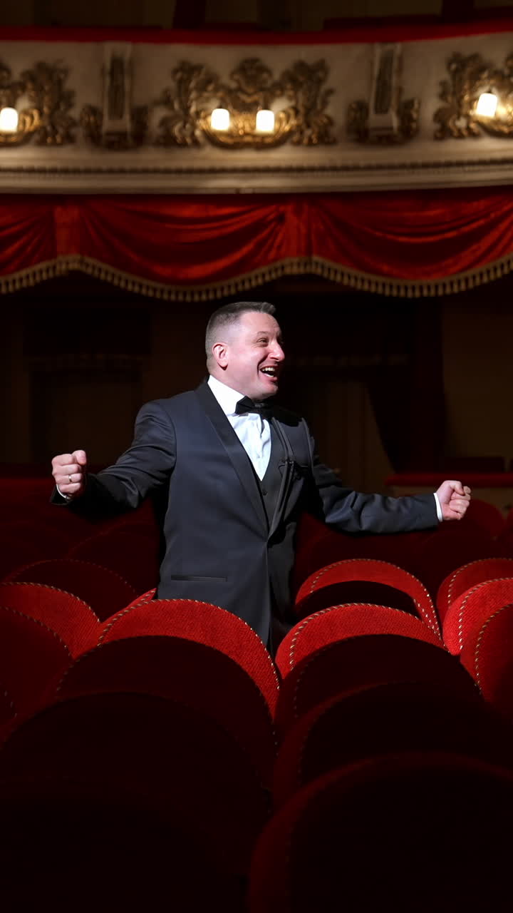 Comedian speaking in dark theater without people. Mad actor shouting in empty theatrical hall and calls someone. Consequences of pandemic. Vertical video