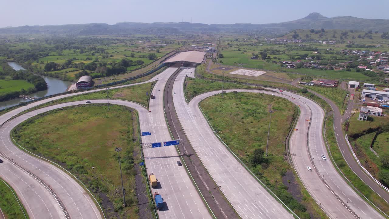 Samruddhi Mahamarg expressway interchange, Kasara Igatpuri tunnel through fertile agricultural fields, rural village and Sahyadri hills, Maharashtra, Drone shot