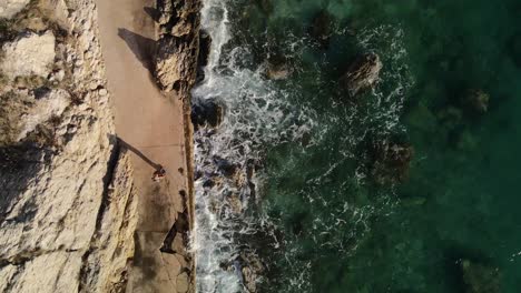 shot overhead starting with a dolly following the woman walking followed by a left turn in baska croatia wonderful place of peace