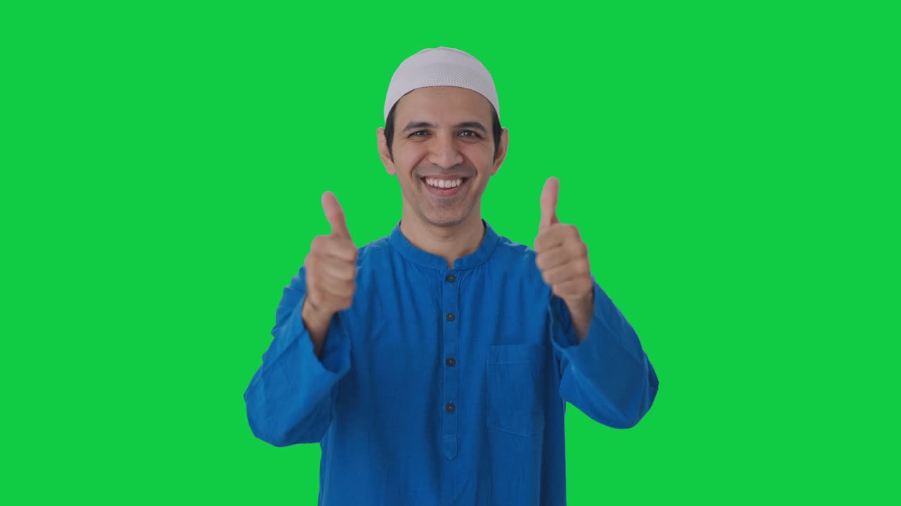 행복한 무슬림 남자가 엄지손가락을 보여주는 녹색 화면