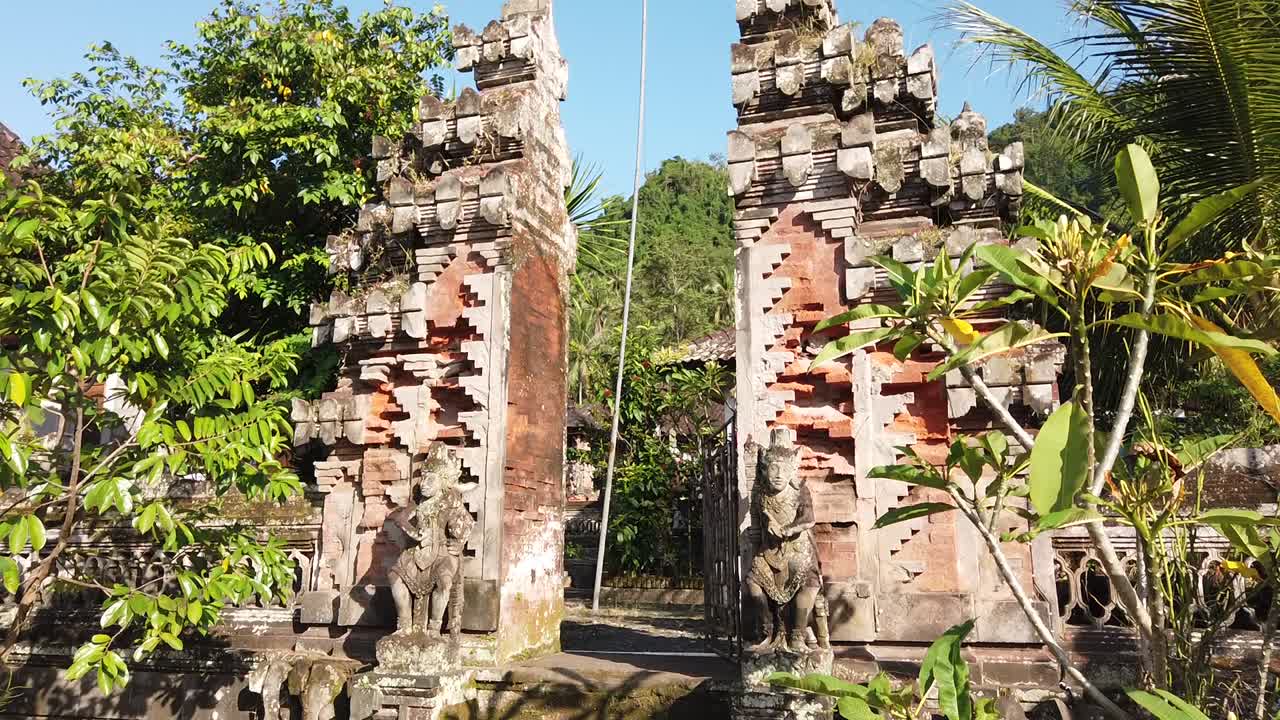Temple Gate Entrance Architecture in Beautiful Green Village with Blue Sky Bali indonesia Plants and Palm Trees Waving, Religious and Calm Atmosphere Sidemen Karangasem