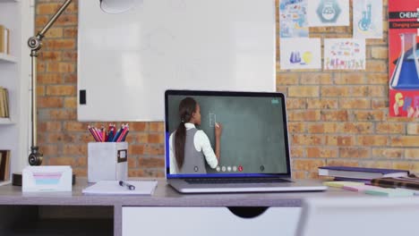maestra de raza mixta en la pantalla de la computadora portátil durante una videollamada