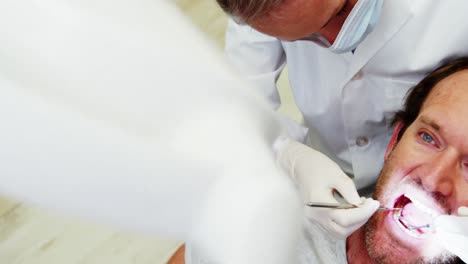 una dentista examinando a un paciente con herramientas dentales