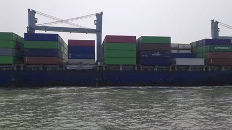 huge container ship leaving the port of mumbai, busiest cargo shipping port of india, handling many ultra-large container ships in harbour terminals mumbai. marine air pollution aerial smog.