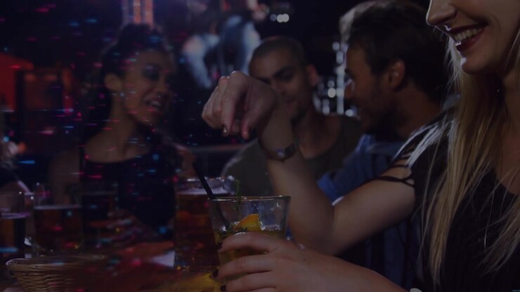 Donna bionda in canotta che prende un cocktail, posiziona una fetta di agrume e mescola la bevanda al bar, con spazio per il testo.