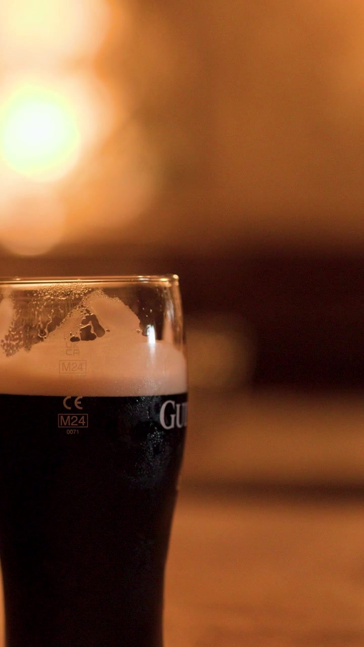 Primo piano di una pinta di birra Guinness in un'accogliente atmosfera da pub.