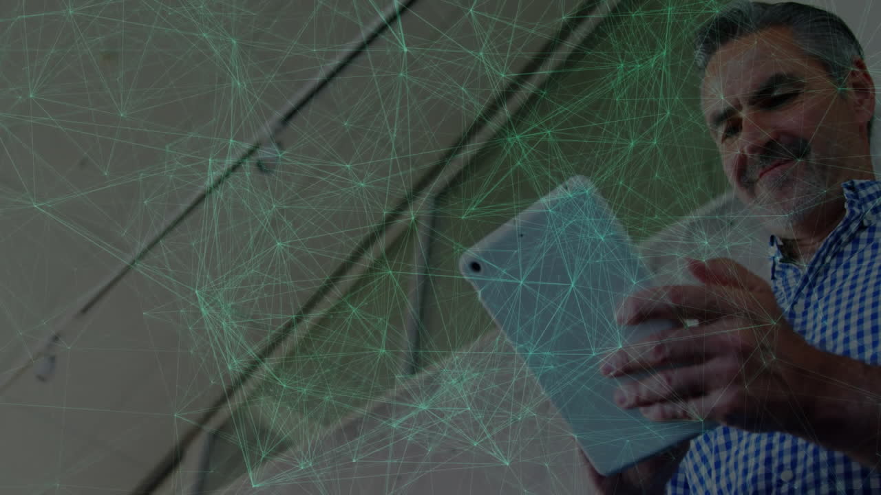 Man interacting with tablet indoors, displaying animated green network nodes for technology visuals