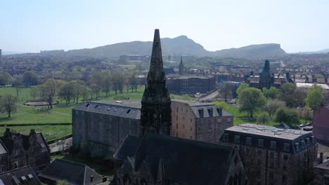 una órbita lenta alrededor del campanario de una iglesia con el asiento de arturo y los riscos | enlaces leith, edimburgo, escocia | filmado en 4k a 30 fps