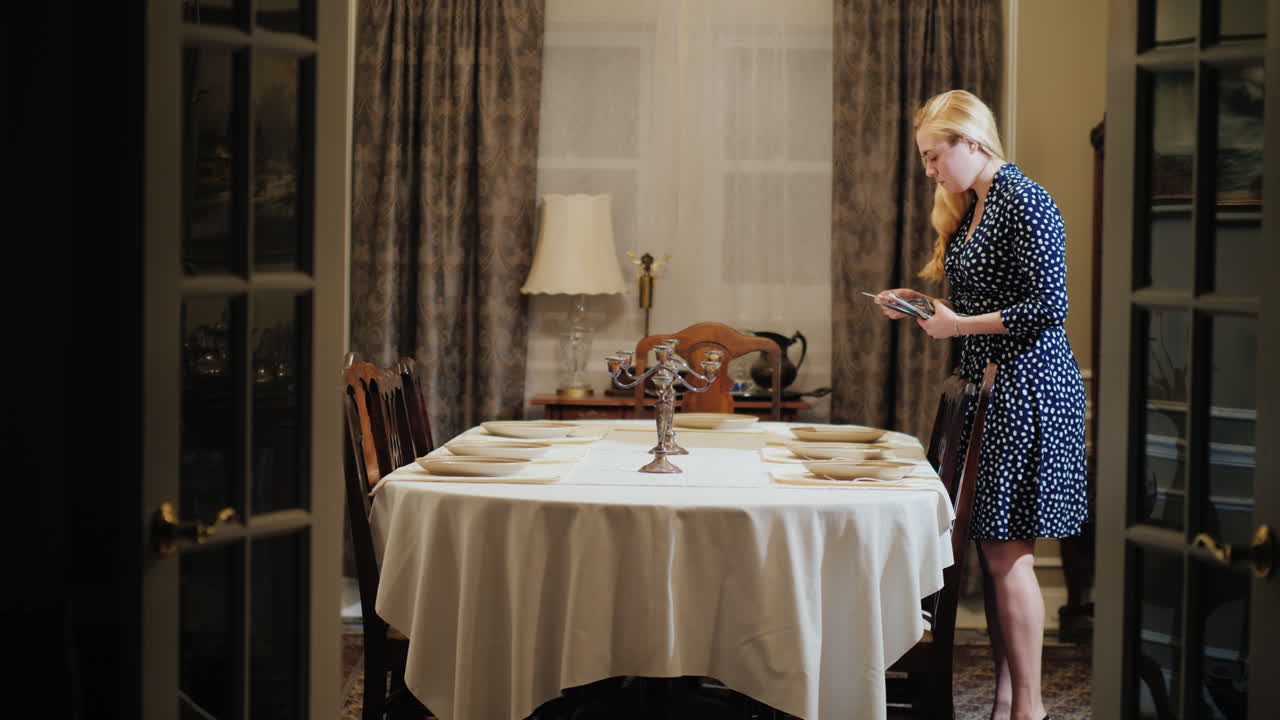 한 여자가 가정 식당에서 테이블을 제공합니다