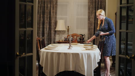 a woman serves a table in a jut home dining room