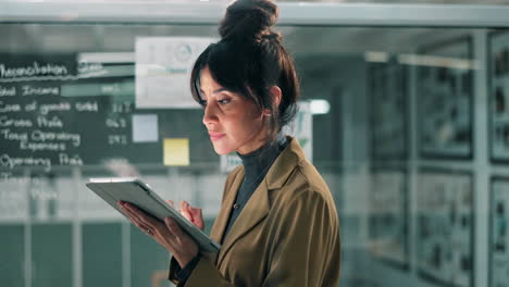 businesswoman analyzing data on a tablet in the office