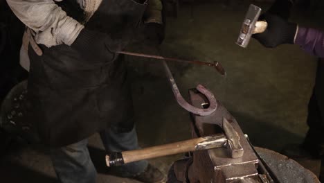 herrero forjando metal en el yunque