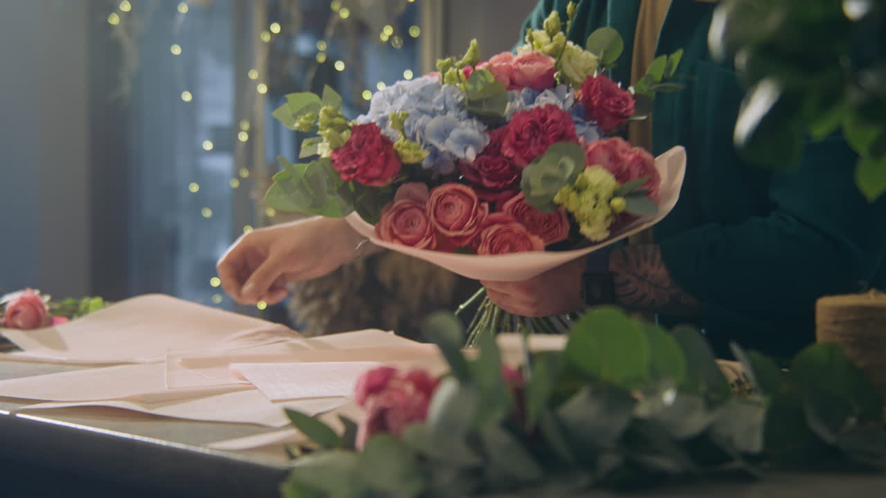 Concentrated Male Florist Wraps Flowers Bouquet