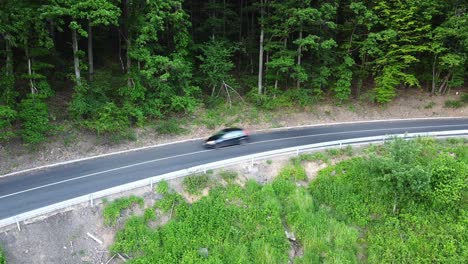 aerial view of cars passing by on a road at a forest during summer