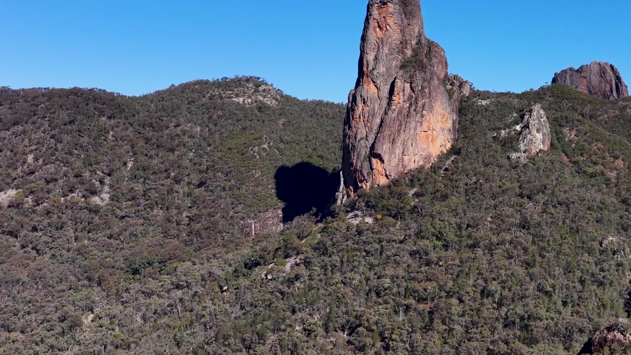 Statisk vidvinkelbilde av fjellspirret The Breadknife under klar blå himmel i Australia.