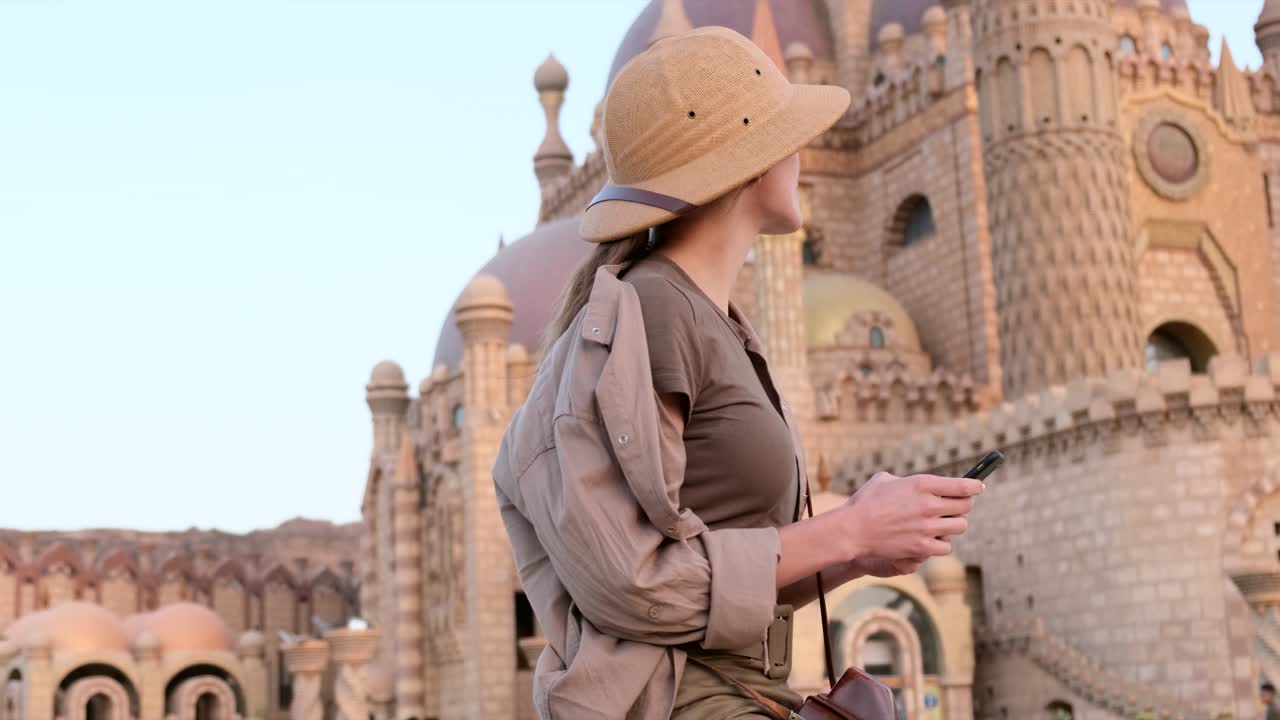 Turista escreve SMS tendo uma mesquita como fundo, Índia.