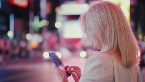 Una-Mujer-Usa-Un-Teléfono-Inteligente-En-Una-Concurrida-Calle-De-Manhattan-Gotas-De-Lluvia-Caen-En-La-Pantalla