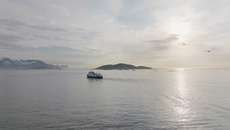 Ferry-cruising-on-fjord-at-sunset,-scenic-calm-arctic-ocean