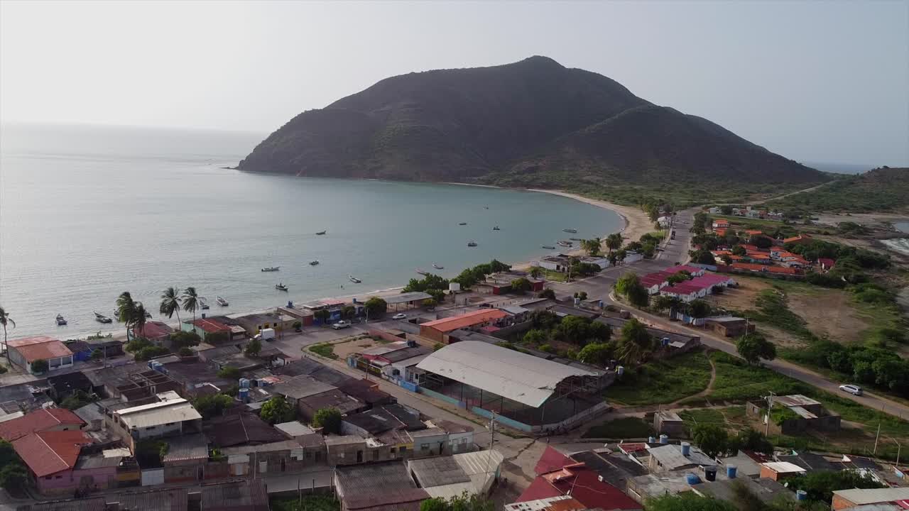Isla de Margarita shore with calm waters and mountains, serene drone view