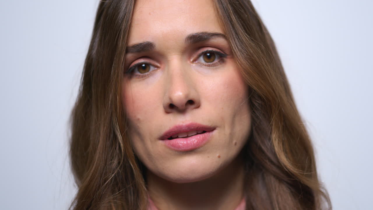 mujer seria agitando la cabeza sí a la cámara. mujer enfocada cara en el estudio