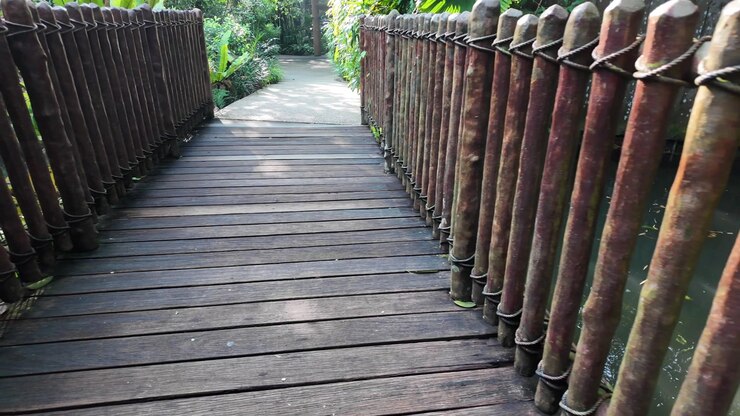 Walking on a Wooden Walkway with Rustic Railings in a Lush Garden