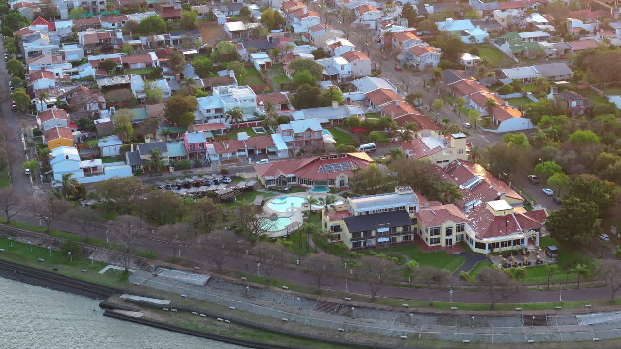 Stunning orbit drone shot captures the costa del sol hotel and the picturesque cityscape of federacion in entre rios, argentina, showcasing its charming neighborhoods and renowned thermal resorts