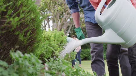 Happy caucasian family working in garden on sunny day