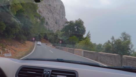 An-amazing-drive-view-by-the-car-windscreen-of-the-curves-at-highway-with-the-forest-Of-Mallorca,-Spain