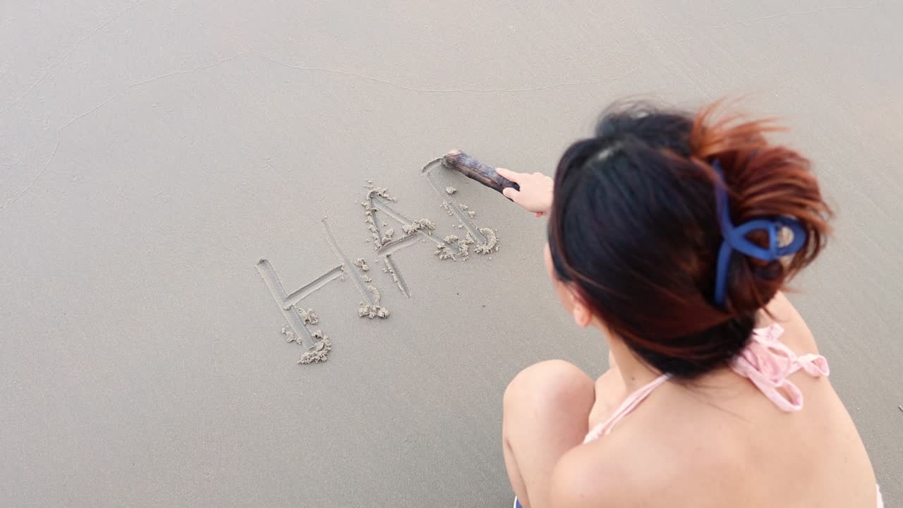 모래 표면에 "행복"이라는 단어를 쓴 사람.