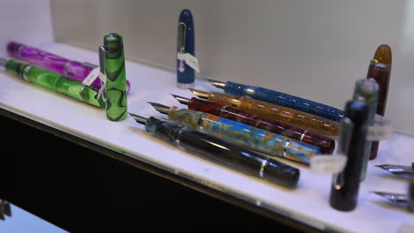 Fountain-pens-are-on-display-for-sale-in-a-pen-shop,-Exploring-the-Artistry-of-Fountain-Pens