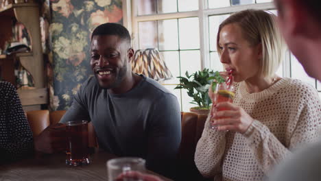 group of friends meeting for lunchtime drinks in traditional english pub