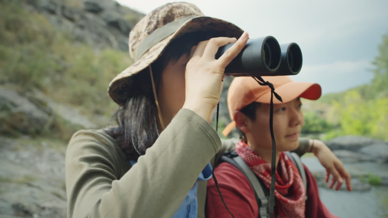 Female Tourists Using Binoculars on Hike