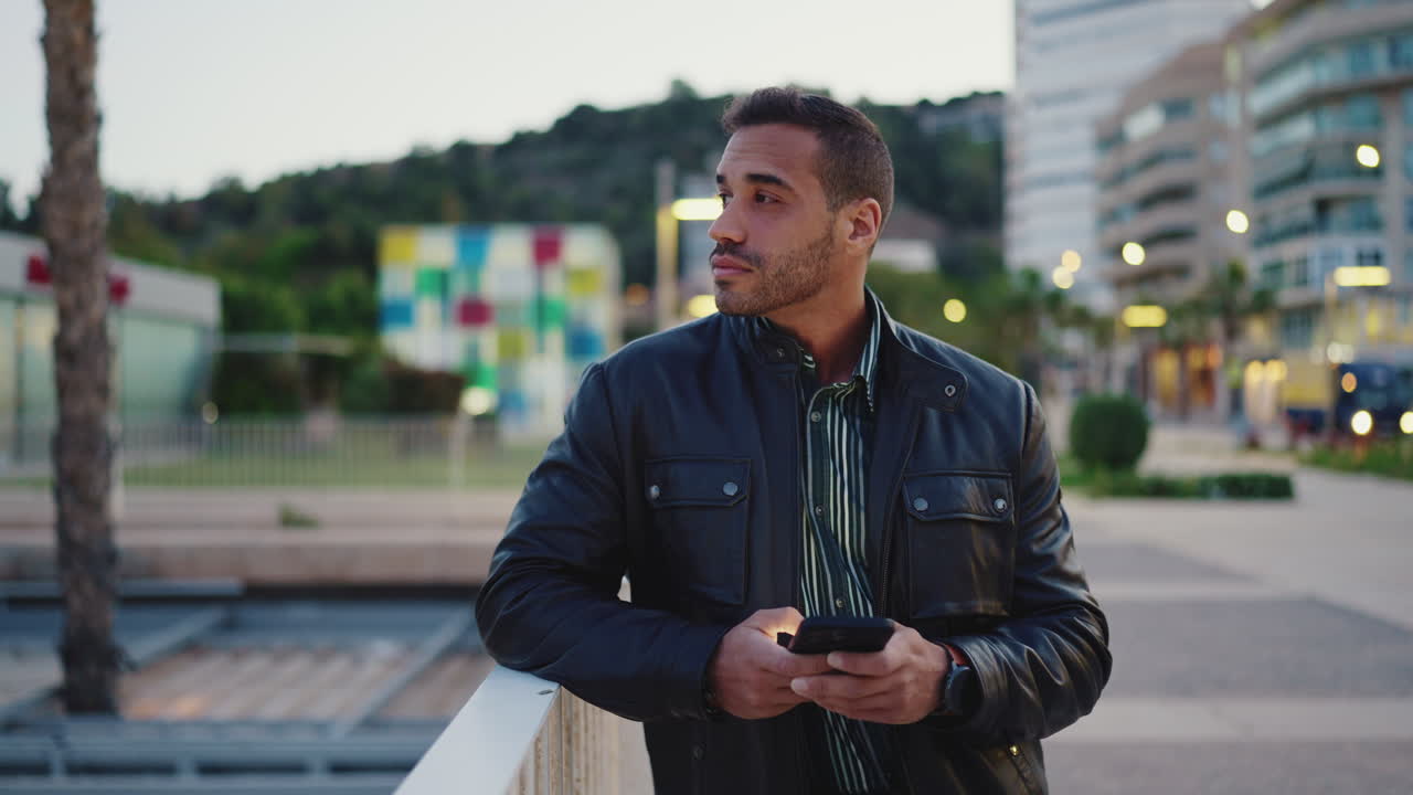 젊은이가 야외에서 스마트폰을 사용하고 있습니다.