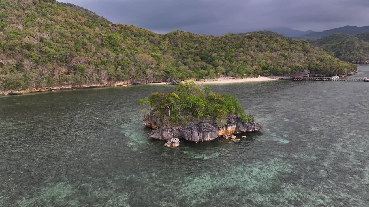 Cinematic aerial over rock formation reveal small beach and tropical remote place of Gua Rangko, Indonesia.