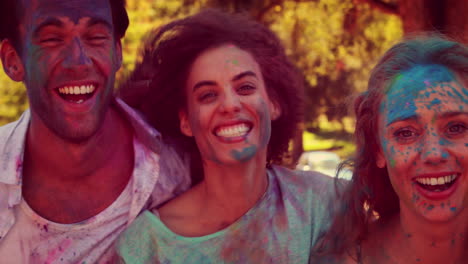 happy friends covered with powder paint smiling at camera