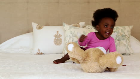 Süßes-Kleines-Mädchen,-Das-Mit-Teddybär-Auf-Dem-Bett-Spielt