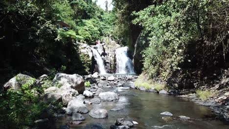 un dron disparó hacia una de las cascadas de alingaling en bali, indonesia, mientras se podía ver a los turistas caminando
