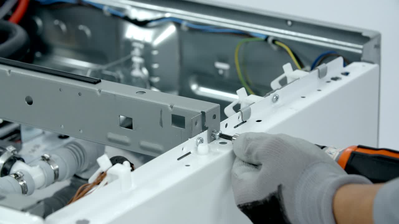Unscrewing screws that hold side boards of the washer