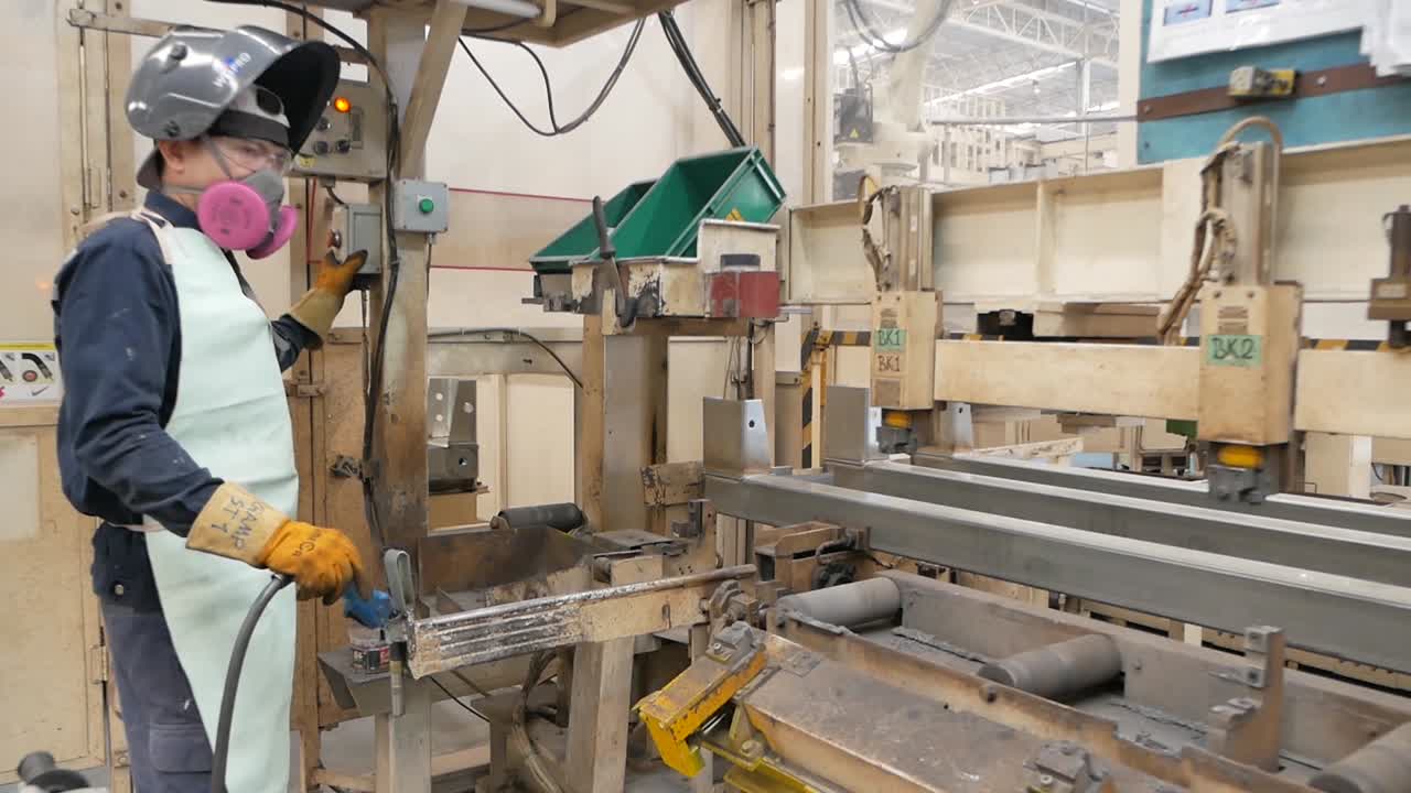 Factory Worker Welding Metal on an Assembly Line