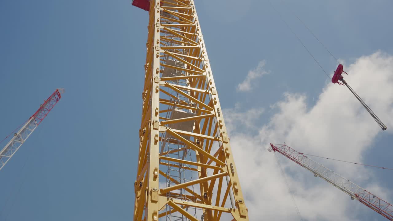 Large construction crane against a clear blue sky. construction site area. Upward view. industrial strength and modern construction. Infrastructure development, urban growth, and engineering