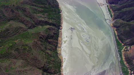 Top-Aerial-flight-view-over-the-river,-Some-houses-on-the-mountain-with-Forests-roads-and-streets